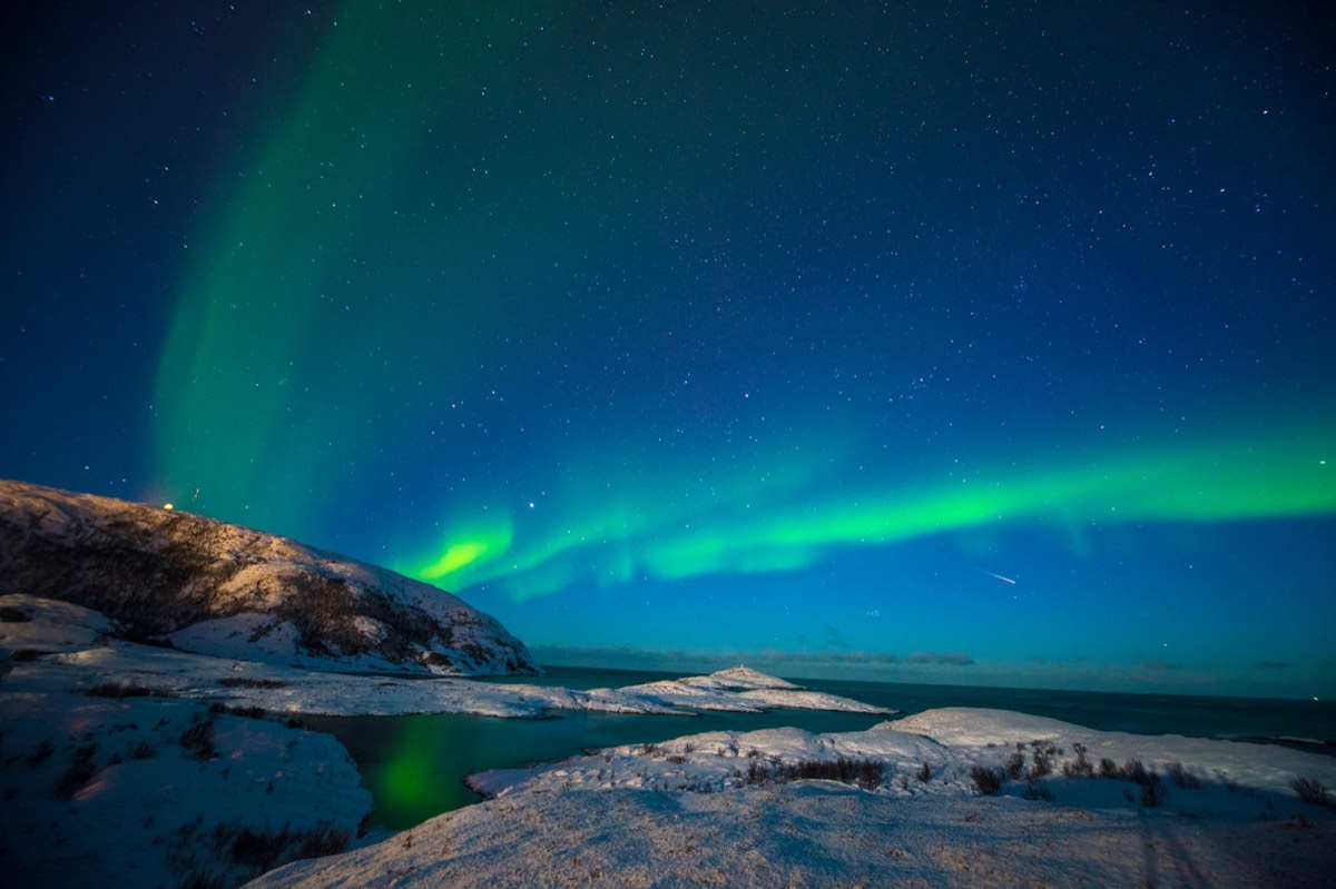 Northern lights stretching across a snowy night sky